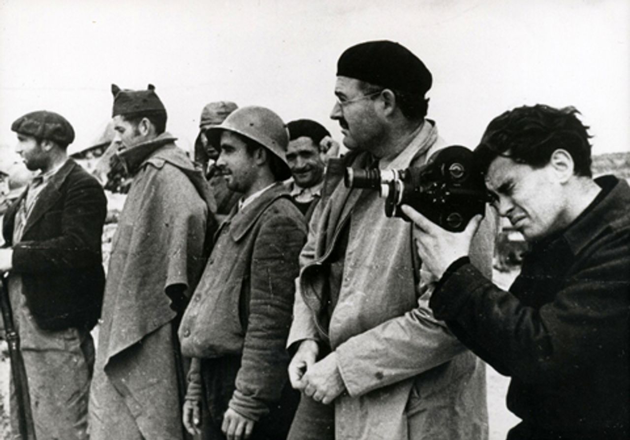 Joris Ivens (holding camera) next to Ernest Hemingway in Spain