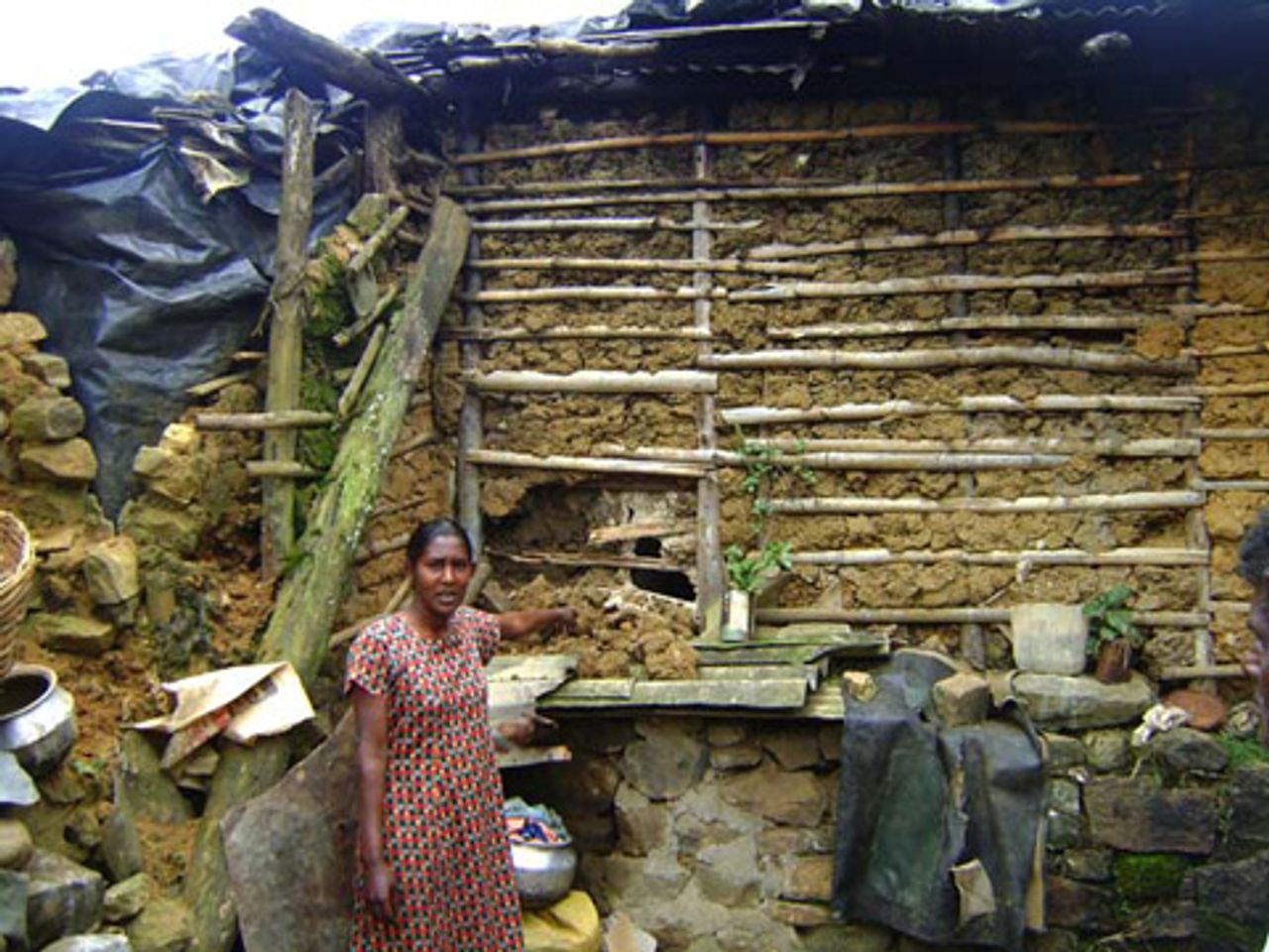 Tea worker points to her damaged kitchen
