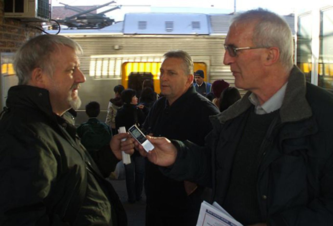 Two utility workers discuss SEP policies at Cabramatta station