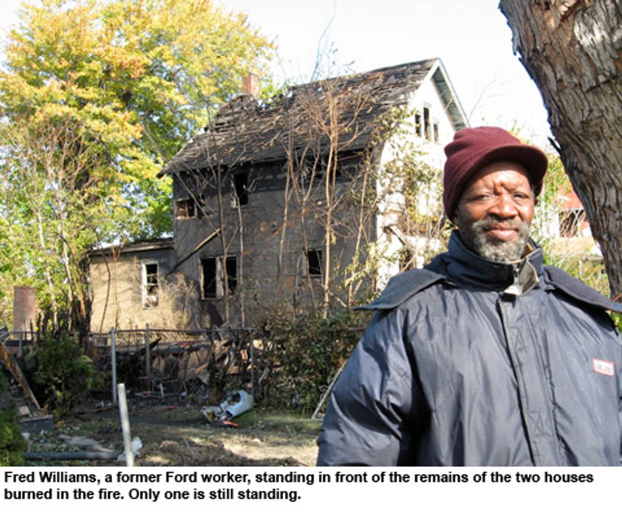 Fred Williams, a former Ford worker, standing in front of the remains of the two houses burned in the fire.  Only one is still standing.